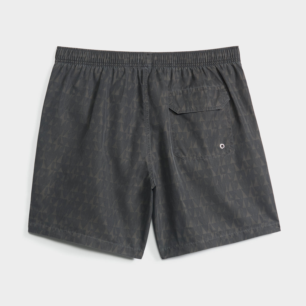The PUBLIC BEACH SWIM PRISM FLOW men's swim shorts come in dark gray with a subtle geometric print, an elastic waistband, and a single back pocket featuring a button flap and metal grommet for drainage.