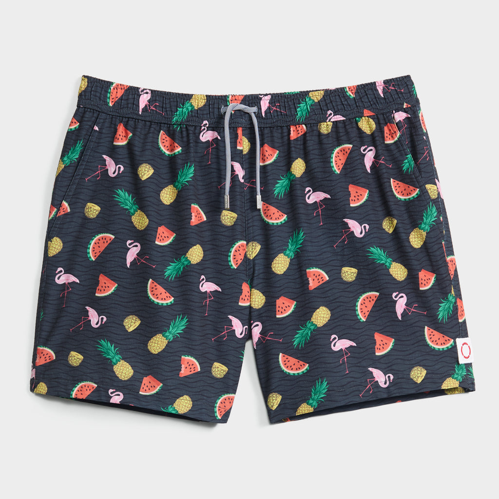 TROPICAL TANGO swim shorts by PUBLIC BEACH SWIM feature a vibrant print of pink flamingos, yellow pineapples, and red watermelons, plus a white drawstring waist and an inner compression liner for extra comfort.