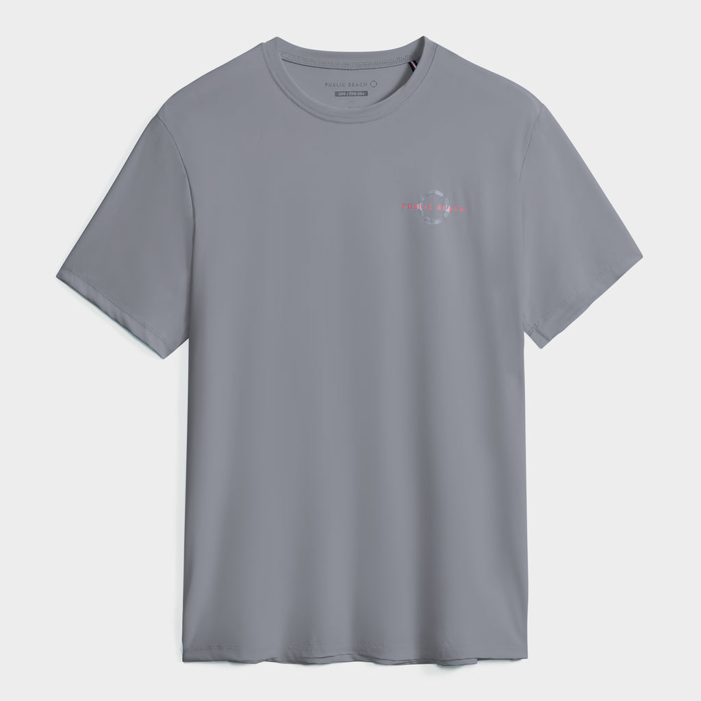 The PUBLIC BEACH SWIM SHORT SLEEVE RASHGUARD is a plain grey men’s tee with a small left-chest logo and text, UPF 50 sun protection, and short sleeves, shown on a white background.