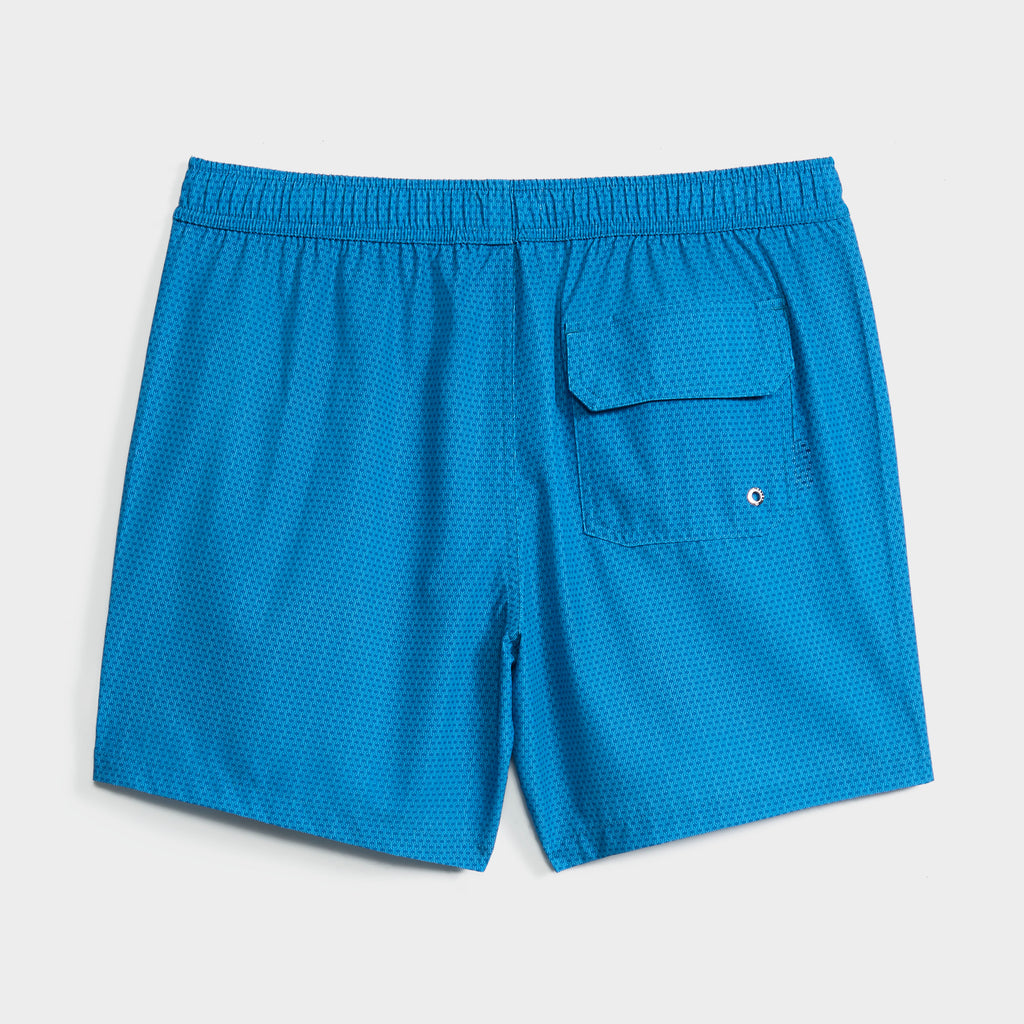 The PUBLIC BEACH SWIM LINK FLOW men's bright blue swim short features a subtle dotted pattern, elastic waistband, and back flap pocket with drainage hole. Quick-dry, perfect for the beach. Shown on a plain white background.