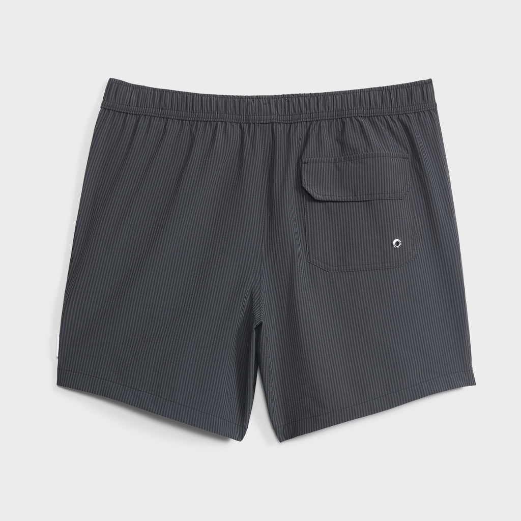 The SAINT TROPEZ men’s swim shorts by PUBLIC BEACH SWIM feature a dark gray pinstripe, elastic waistband, and back flap pocket with grommet. These quick-dry trunks are shown laid flat on a white background.