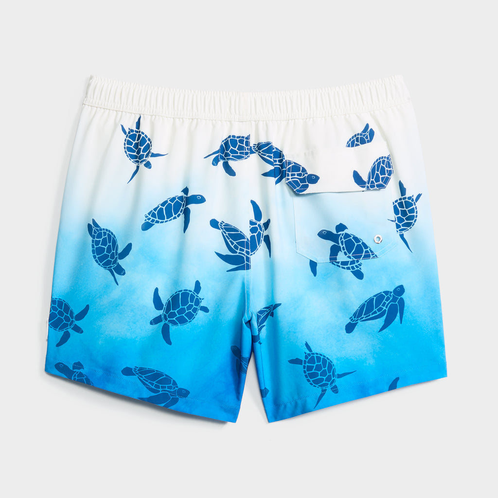 The TURTLE WAVES men’s swim short by PUBLIC BEACH SWIM features a blue and white gradient with dark blue sea turtles, quick-dry fabric, an elastic waistband, back pocket with button, and a comfortable compression liner for support.