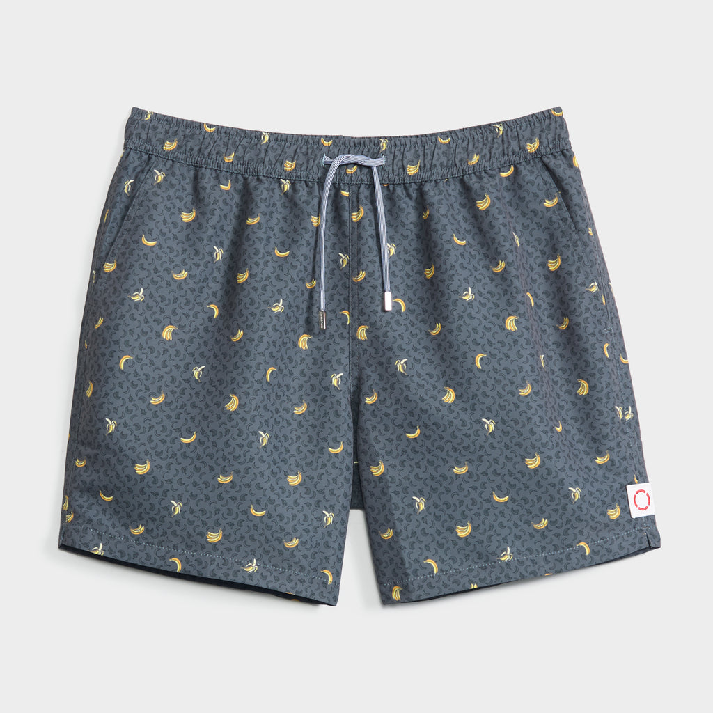 PEEL PARTY swim shorts by PUBLIC BEACH SWIM feature a playful banana and palm tree print, quick-dry fabric, white waist drawstring, and a small white patch with a red circle on the front left hem.
